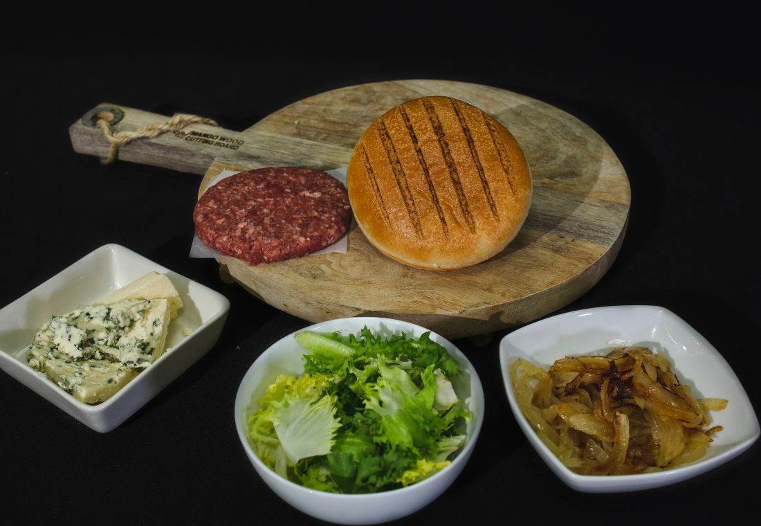 Hambúrguer grelhado com carne de vitela, queijo azul e alface encaracolada